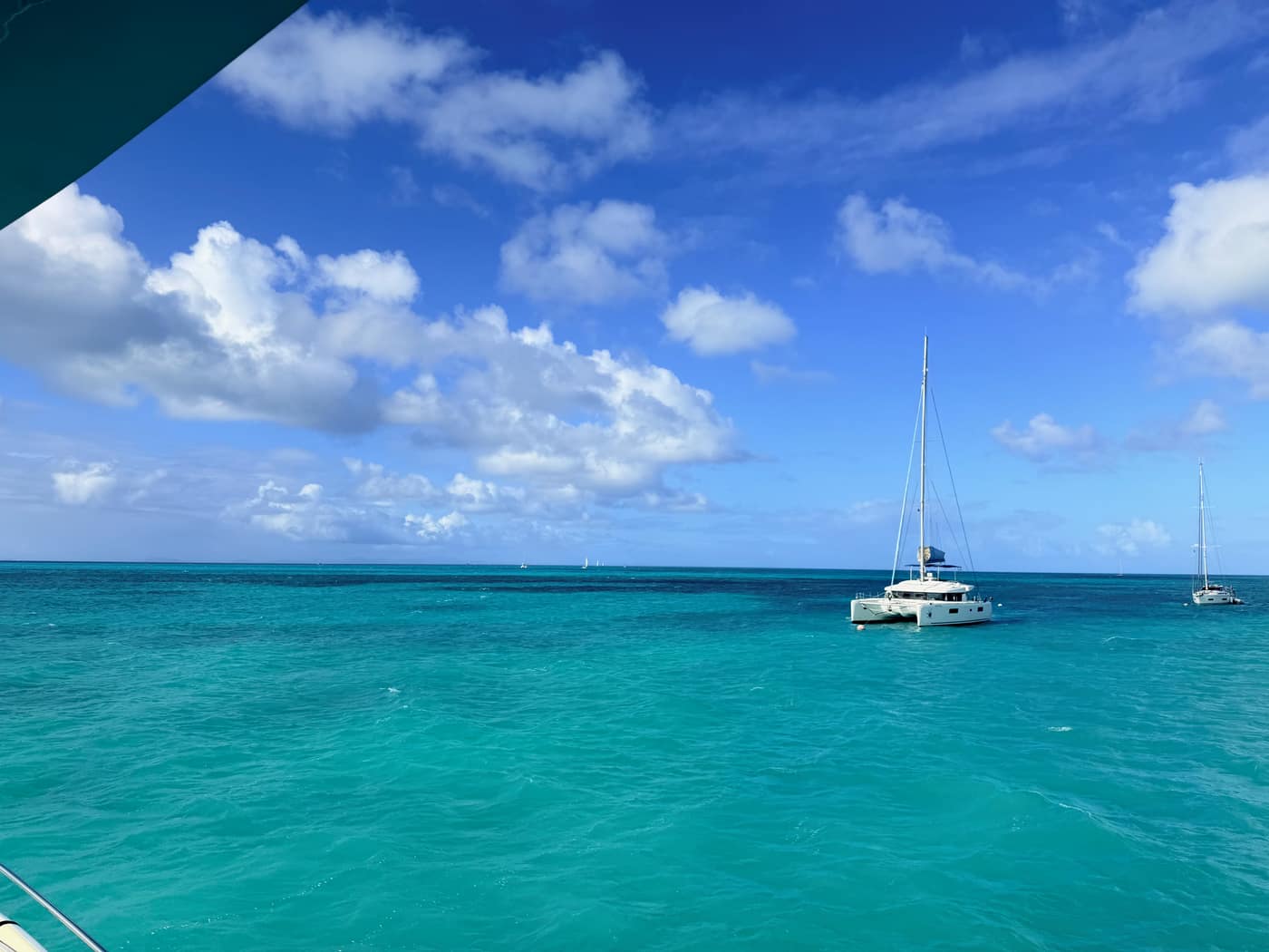 Open water crossing to Anegada with a catamaran under sail on flat blue water.