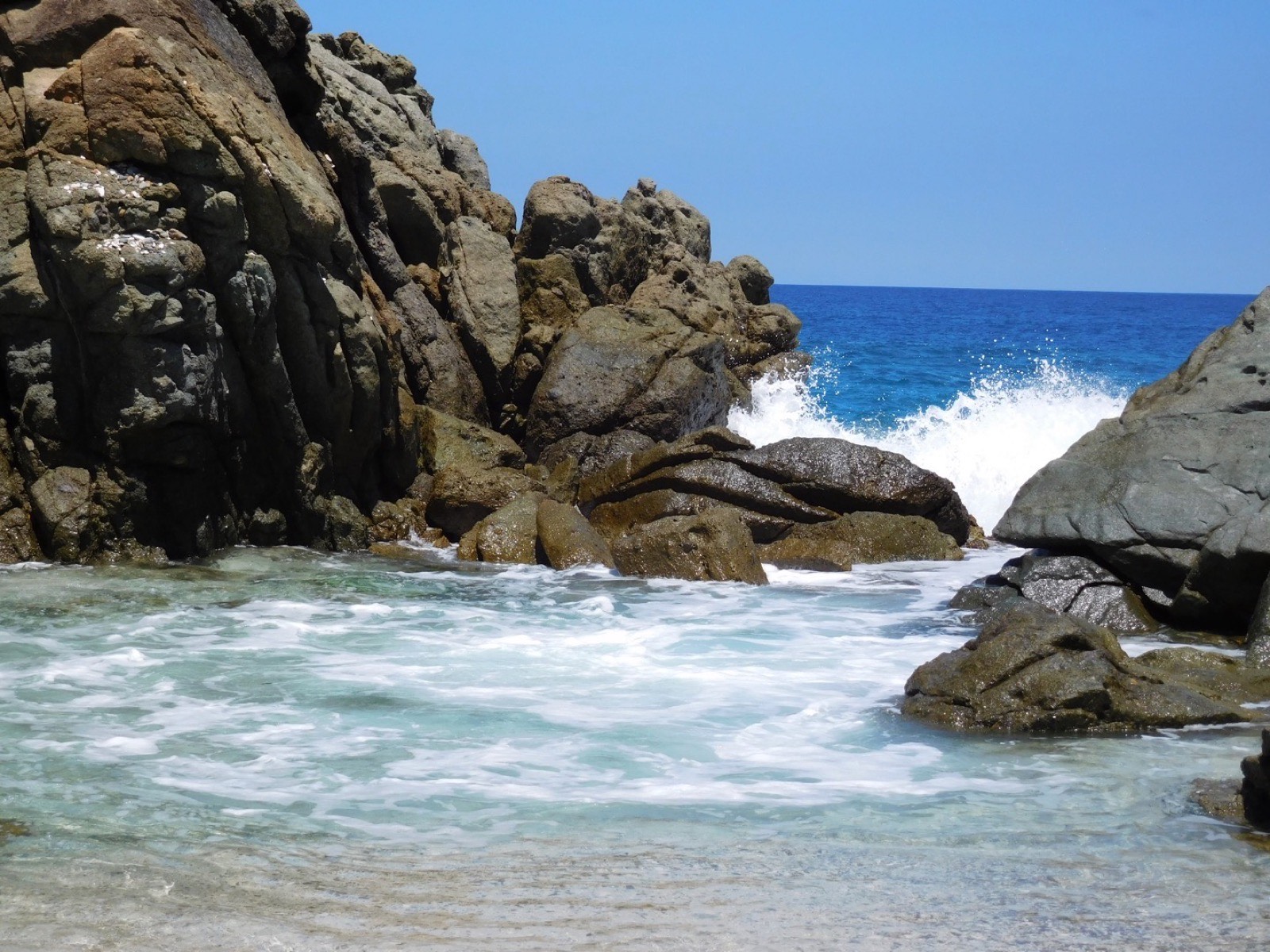 The Bubbly Pool on the north side of Jost Van Dyke, surf pushing through the rocks into a natural pool.